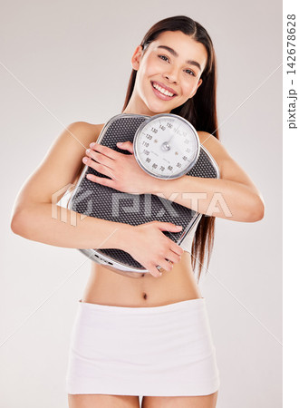 Studio, portrait or girl with smile or scale for body training, fitness or gym workout to lose weight. Model, woman or happy sports athlete on white background to exercise or monitor progress results 142678628
