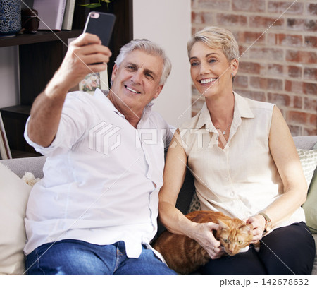 Senior couple, selfie and smile on sofa in home with cat for fun, living room or apartment for post on social media. Retirement, people and happy for pet, profile picture or video call on smartphone Senior couple, selfie and smile on sofa in home with cat for fun, living room or apartment for post on social media. Retirement, people and happy for pet, profile picture or video call on smartphone 142678632
