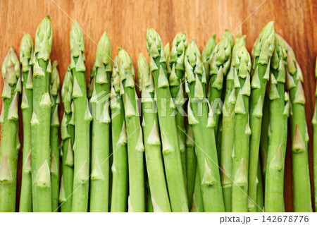 Vegetables, asparagus and food for diet, ingredients and prepare meal in kitchen with green produce on wood table. Dinner, lunch and catering with healthy cuisine, fresh and organic for vegan 142678776