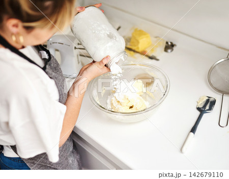 Woman, bowl and mixture with flour for baking in house with food and hands for hobby in kitchen. Professional, dessert and cooking on table for small business or home recipe with ingredients. Woman, bowl and mixture with flour for baking in house with food and hands for hobby in kitchen. Professional, dessert and cooking on table for small business or home recipe with ingredients. 142679110