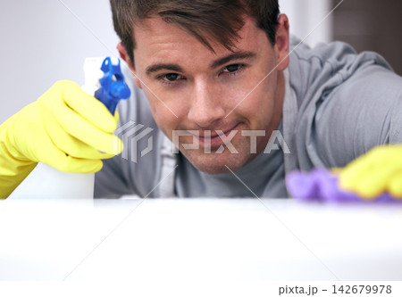 Man, spray and bottle for cleaning surface of dirt or dust in home for health and hygiene and maintenance. Person, chemical detergent and housekeeping or housework for disinfection or sanitize. Man, spray and bottle for cleaning surface of dirt or dust in home for health and hygiene and maintenance. Person, chemical detergent and housekeeping or housework for disinfection or sanitize. 142679978