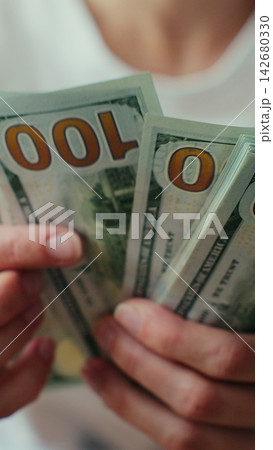 Vertical video. Woman Counting Dollar Bills at Home. 142680330