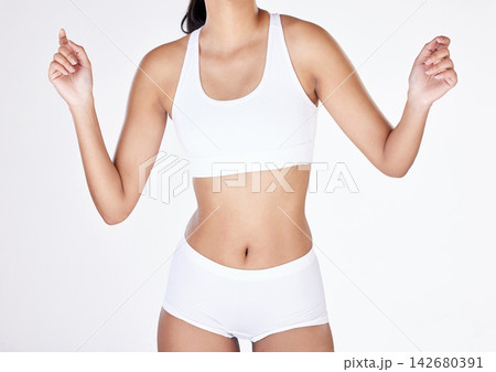 Closeup, body and woman with underwear, hands and fitness on white studio background. Person, balance and model with panty, stomach and exercise with gut health, training and workout with wellness Closeup, body and woman with underwear, hands and fitness on white studio background. Person, balance and model with panty, stomach and exercise with gut health, training and workout with wellness 142680391