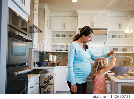 Mother, girl and cookies or helping with cooking for learning, bonding and preparation in kitchen with teaching. Family, woman and daughter with baking dessert, cake and sweet snack with fun in house Mother, girl and cookies or helping with cooking for learning, bonding and preparation in kitchen with teaching. Family, woman and daughter with baking dessert, cake and sweet snack with fun in house 142680711