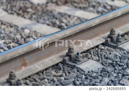 Close-up view of train rails showcasing the intricate details of metal and gravel on a bright sunny day Close-up view of train rails showcasing the intricate details of metal and gravel on a bright sunny day 142680893