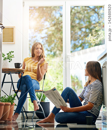 Relax, talking and sisters in kitchen with coffee for morning gossip, bonding or sharing story. Women, twins or weekend chat with news, conversation and sitting together in home for social connection Relax, talking and sisters in kitchen with coffee for morning gossip, bonding or sharing story. Women, twins or weekend chat with news, conversation and sitting together in home for social connection 142680920