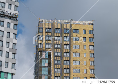 Urban development shapes the skyline as new buildings rise under a cloudy sky in a bustling city quarter Urban development shapes the skyline as new buildings rise under a cloudy sky in a bustling city quarter 142681759