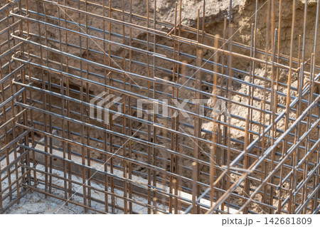 Steel framework rising from the earth in a construction site amidst the bright afternoon light Steel framework rising from the earth in a construction site amidst the bright afternoon light 142681809
