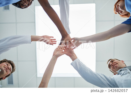 People, hands together and below with medical team for unity, meeting or motivation at hospital. Low angle or closeup of group piling or touching in collaboration, solidarity or mission at clinic People, hands together and below with medical team for unity, meeting or motivation at hospital. Low angle or closeup of group piling or touching in collaboration, solidarity or mission at clinic 142682057