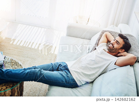 Man, relax and sofa in home with smile or comfortable peace in living room for afternoon, resting or day off. Male person, couch and leisure in England apartment with lazy Saturday, lying or happy Man, relax and sofa in home with smile or comfortable peace in living room for afternoon, resting or day off. Male person, couch and leisure in England apartment with lazy Saturday, lying or happy 142682162