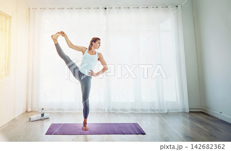 Yoga, woman and stretching leg in home on mat with balance, flexibility and posture for fitness. Yogi, pilates and exercise in studio with workout routine, practice and performance for healthy body Yoga, woman and stretching leg in home on mat with balance, flexibility and posture for fitness. Yogi, pilates and exercise in studio with workout routine, practice and performance for healthy body 142682362