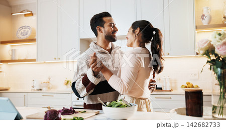 Dancing, food and couple in kitchen at house listening to music, playlist or radio together. Happy, cooking and man with woman for moving to song for bonding, care and connection in home on weekend. Dancing, food and couple in kitchen at house listening to music, playlist or radio together. Happy, cooking and man with woman for moving to song for bonding, care and connection in home on weekend. 142682733