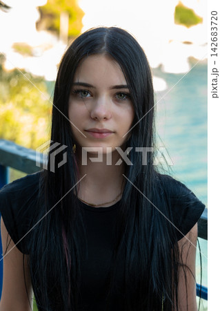 Young woman with long black hair posing outdoors in soft light 142683720