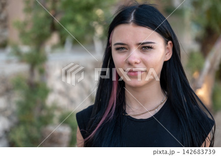 Young woman with dark hair and pink streaks outdoors portrait 142683739