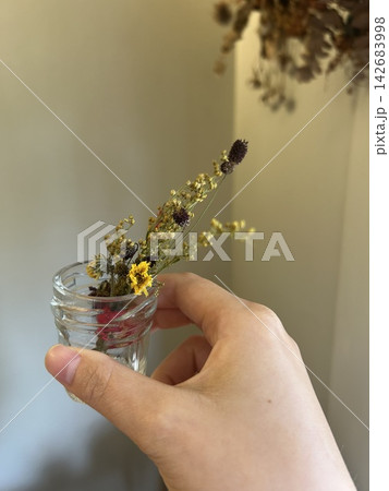 花の入った小瓶を持つ女性の手 花の入った小瓶を持つ女性の手 142683998