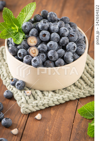 Fresh ripe blueberries in a bowl on wooden surface Fresh ripe blueberries in a bowl on wooden surface 142684822