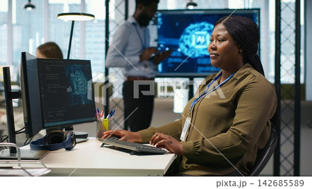 Female admin using AI neural networks tech on computer to optimize performance and forecast issues. Woman in office training artificial intelligence deep learning models using PC, camera A Female admin using AI neural networks tech on computer to optimize performance and forecast issues. Woman in office training artificial intelligence deep learning models using PC, camera A 142685589