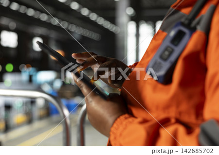 Close up of black employee handling worksite manufacturing process in heavy industry facility, industrial space with massive equipment used for the production line. Engineering plant. Close up of black employee handling worksite manufacturing process in heavy industry facility, industrial space with massive equipment used for the production line. Engineering plant. 142685702