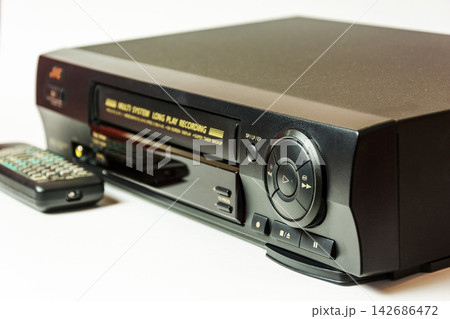 Vintage VHS Player with Remote Control on White Background 142686472