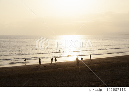 湘南片瀬西浜  夕陽に照らされた海と人々のシルエット 142687118