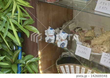 老舗飲食店のショーケースに飾られた招き猫と手書きメニュー 老舗飲食店のショーケースに飾られた招き猫と手書きメニュー 142689348