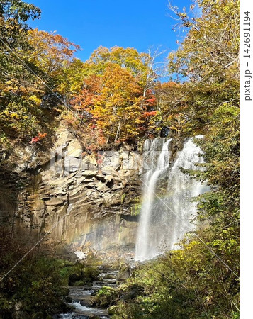紅葉に彩られた岩肌を豪快に流れ落ちるアシリベツの滝 142691194