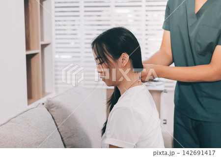 Professional doctor performing a spinal examination on a female patient. Professional doctor performing a spinal examination on a female patient. 142691417
