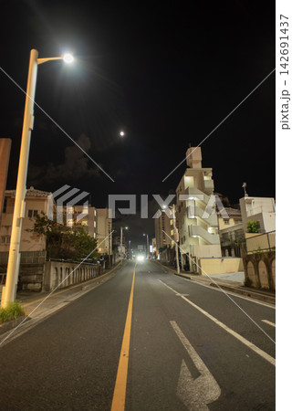 夜の月と街灯がある車も人も通っていない長い直線の通り 夜の月と街灯がある車も人も通っていない長い直線の通り 142691437