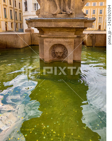A large, stone fountain filled with vibrant green water 142692094