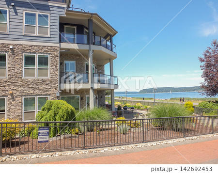 Modern upscale residential condominium building with stone facade next to the sea in Ruston, - June 13, 2026 Ruston WA, USA 142692453