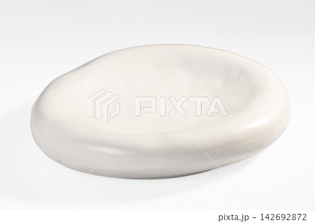 Smooth white ceramic dish with organic oval shape and glossy finish on plain white background Smooth white ceramic dish with organic oval shape and glossy finish on plain white background 142692872