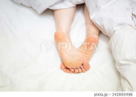 ベッドに寝転ぶ女性の足元 ベッドに寝転ぶ女性の足元 142693496