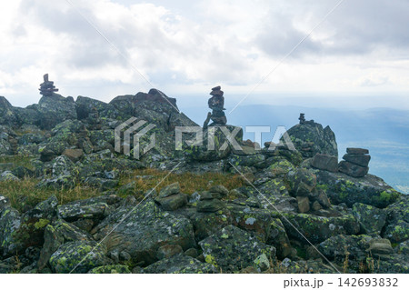 Mountains plateau with rocks and stone cairns Mountains plateau with rocks and stone cairns 142693832
