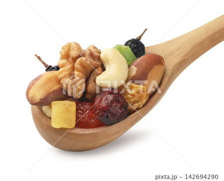 A mix of dried fruits and nuts in a wooden spoon on a white background. Isolated. A mix of dried fruits and nuts in a wooden spoon on a white background. Isolated. 142694290