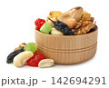 A mix of nuts and dried fruits in a wooden bowl on a white background. Isolated 142694291