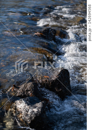 The river rushed over the rocks, creating a spray of mist in the bright sunlight. The spray sparkled in the sun, creating a beautiful sight. The river rushed over the rocks, creating a spray of mist in the bright sunlight. The spray sparkled in the sun, creating a beautiful sight. 142694568