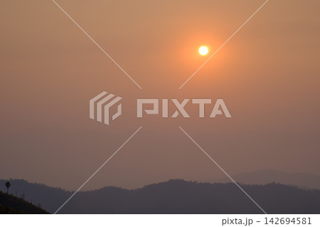 sunset view from the mountain topphoto has focused on a tree branch and partly blur on other subject 142694581