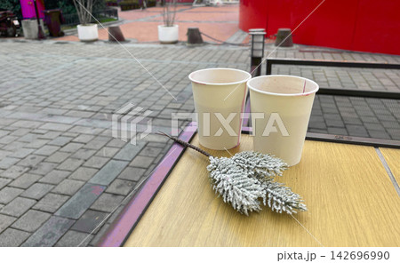 two cups on a table with a small plant two cups on a table with a small plant 142696990