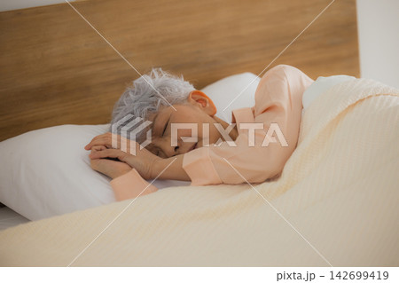 ベッドで眠る高齢者女性 142699419