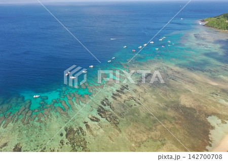 空撮した石垣島のダイビングスポット大崎に浮かぶボートとサンゴ礁の海 空撮した石垣島のダイビングスポット大崎に浮かぶボートとサンゴ礁の海 142700708