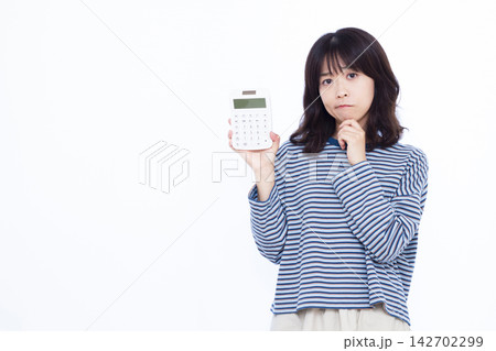 電卓を持って真剣に悩んでいる女性 142702299