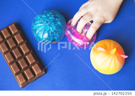 Child's hand playing with colorful fidget toys 142702350
