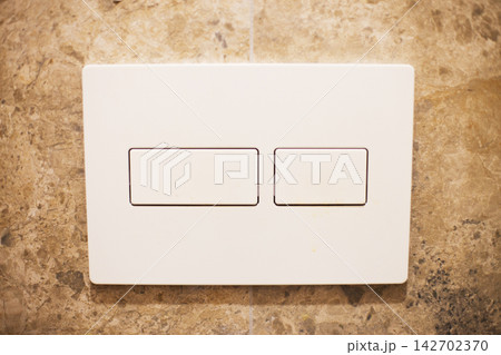 White dual light switch on textured beige wall White dual light switch on textured beige wall 142702370