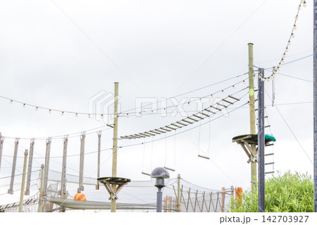 High suspension bridge in a rope amusement park, obstacle course for children in a rope park 142703927
