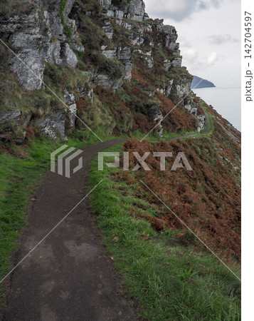 Coastal Path winding around rugged cliffs, Valley of Rocks, Exmoor, Devon Coastal Path winding around rugged cliffs, Valley of Rocks, Exmoor, Devon 142704597