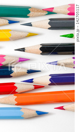 High angle view of various sharp colorful artist pencils scattered horizontally across a frame 142705117