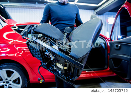 Car service worker disassemble the interior of the car Car service worker disassemble the interior of the car 142705756