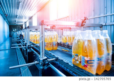 Modern strapping and transporting machine for packaging line at beverage plant. Modern strapping and transporting machine for packaging line at beverage plant. 142705765