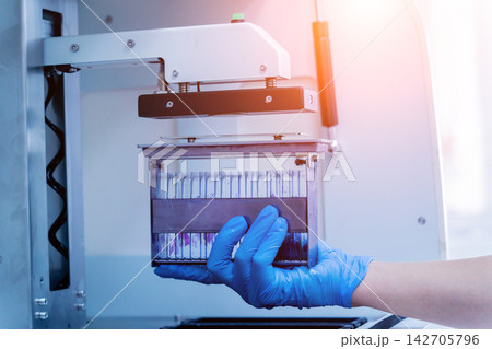 Laboratory assistant works with automatic multi slides stainer at the modern laboratory. Laboratory assistant works with automatic multi slides stainer at the modern laboratory. 142705796
