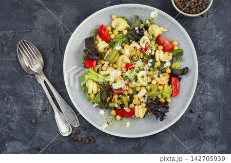 Tri color pasta salad with chickpeas, lettuce and cherry tomatoes 142705939